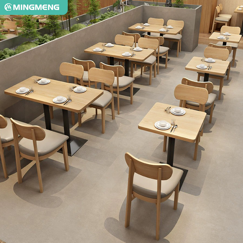 Minimalist wooden dining tables and chairs setup in a modern restaurant setting.
