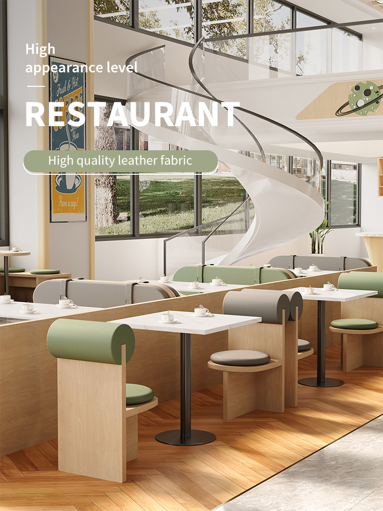 A modern high-aesthetic restaurant featuring stylish white tabletops and green and gray leather-upholstered seats. 
