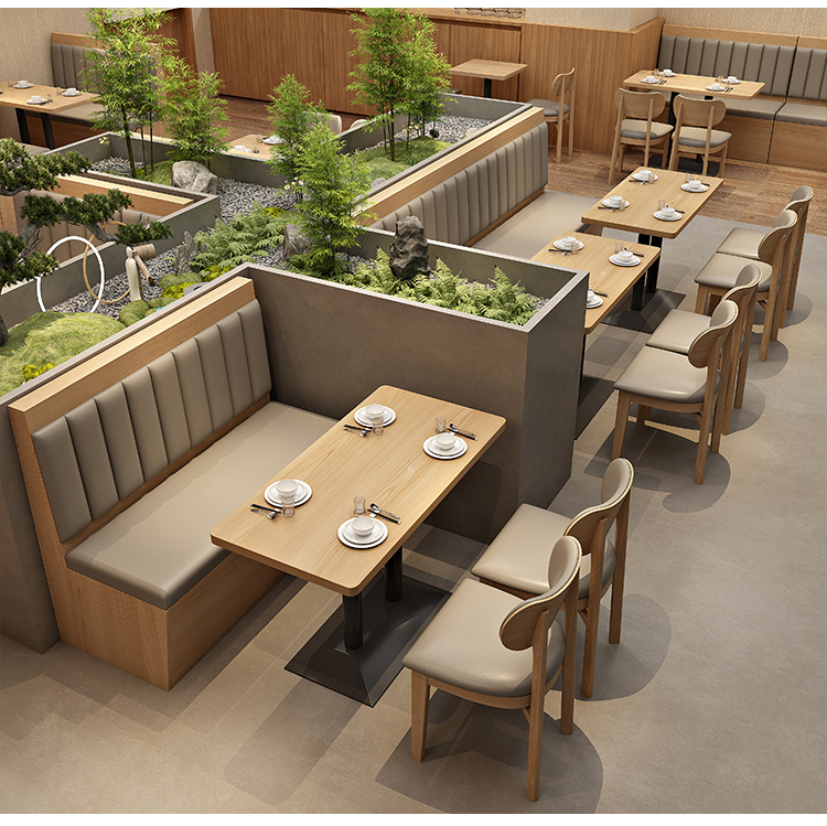 Restaurant seating area with wooden tables, cushioned bench seating, chairs, and garden-inspired decor in the background.
