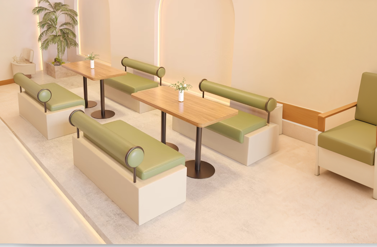 Contemporary coffee shop furniture with green upholstered sofas, round armrests, and wooden tables, creating a minimalist and modern interior design.