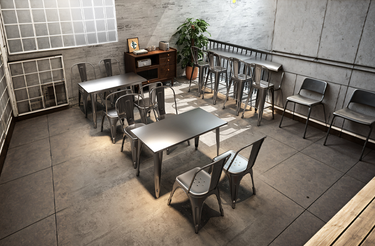 Industrial style coffee shop interior with metal tables and chairs, exposed brick wall, and a cozy corner with a plant and a vintage cabinet.