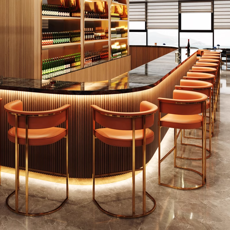 Bar counter with stylish orange and black stools, featuring a modern and luxurious design, surrounded by shelves of wine bottles.