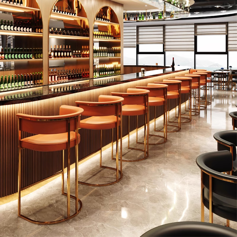 Stylish bar stools with orange cushions and golden frame at a bar counter, showcasing a modern and elegant design.