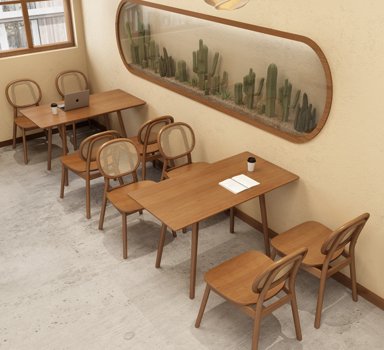 A café dining area with wooden tables, woven chairs, and a unique cactus wall display, perfect for a cozy atmosphere.