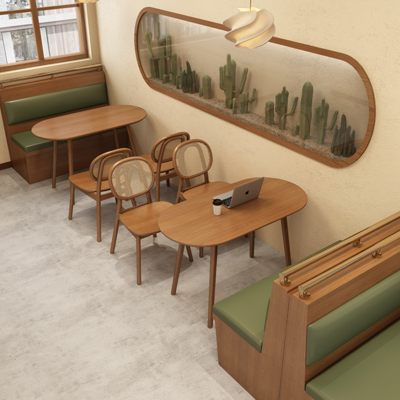 Café with green booth seating, wooden tables, and a unique hanging light design, offering a relaxed ambiance.