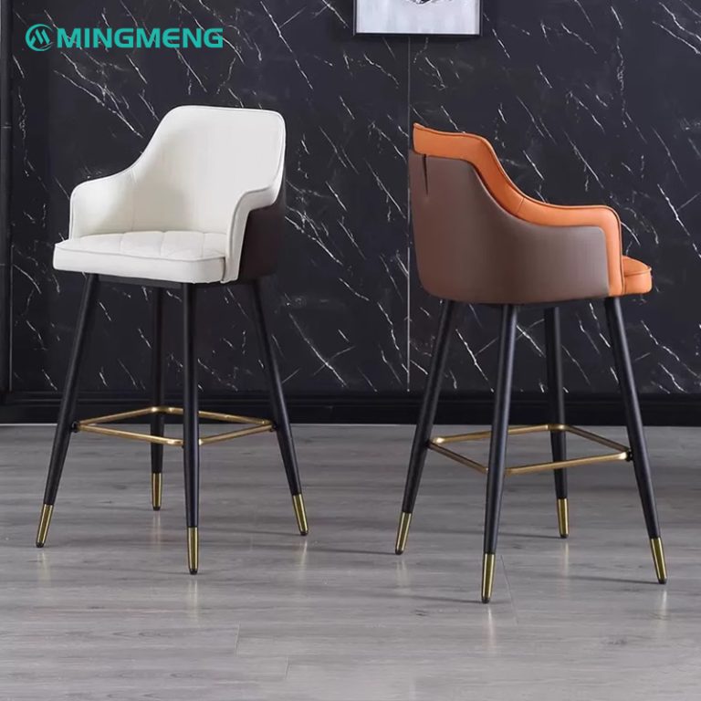 Two stylish barstools with brown and white leather seat and backrest, black steel legs with gold foot caps.