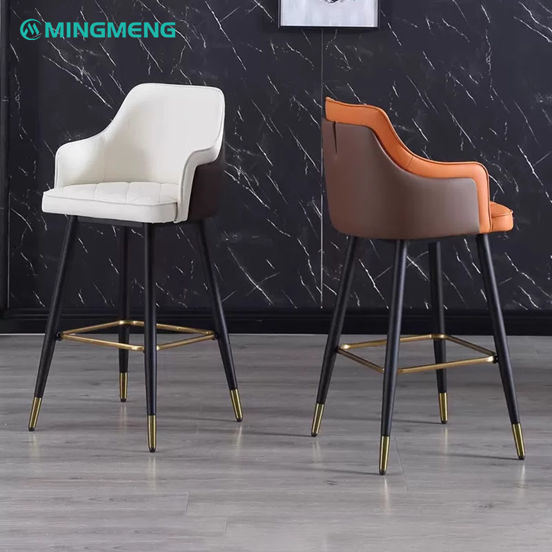Two stylish barstools with brown and white leather seat and backrest, black steel legs with gold foot caps.